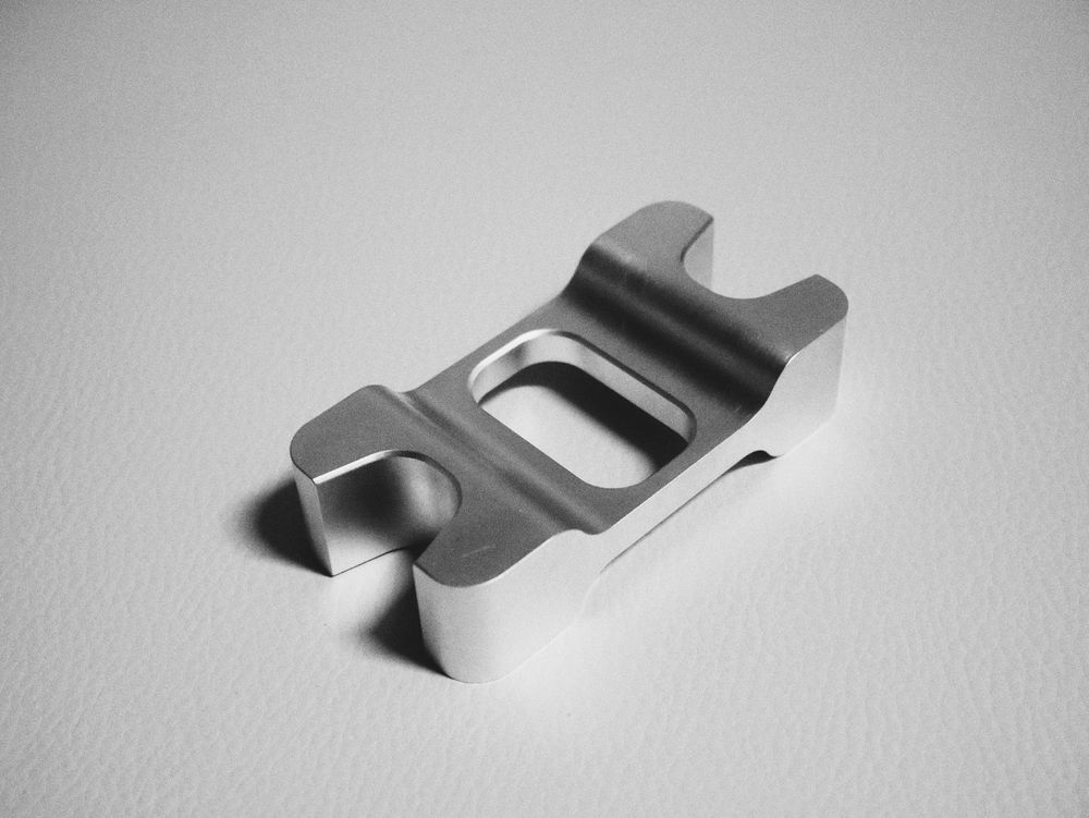 Machined aluminum bracket with slotted ends and center pocket